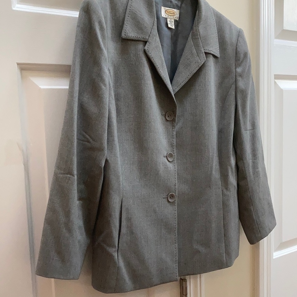 Grey blazer with three buttons and decorative stitching, side pockets